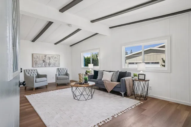 a living room with furniture a rug and wall painting