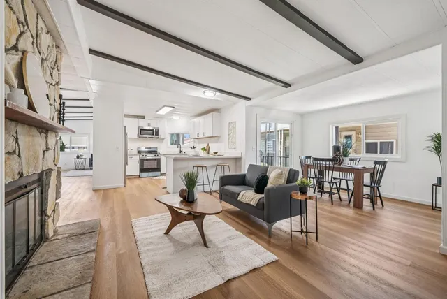 a living room with furniture a fireplace and a table