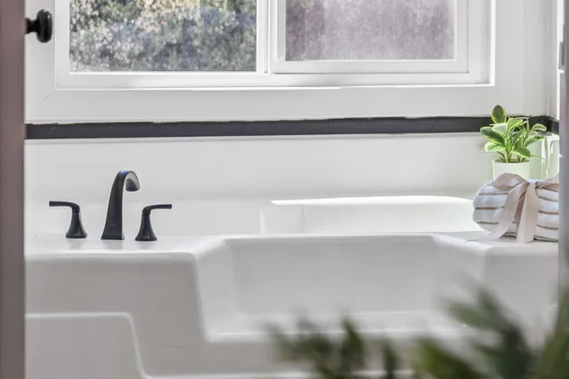 a bathroom with a tub sink and mirror