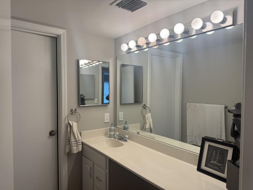 54 La Rue Place Northwest Atlanta, GA 30327 - Photo 11 of 20 a bathroom with a sink a light fixture and a mirror