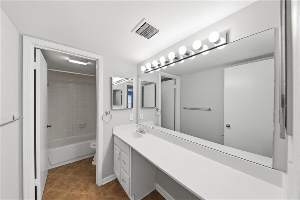 54 La Rue Place Northwest Atlanta, GA 30327 - Photo 19 of 36 a bathroom with a bathtub a shower a sink and a mirror