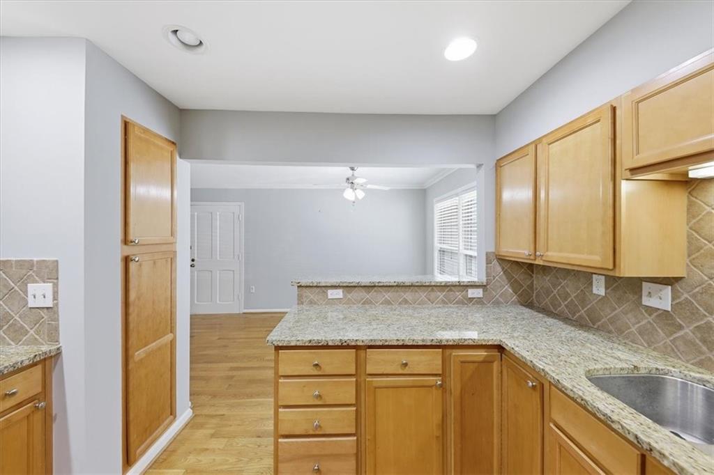 54 La Rue Place Northwest Atlanta, GA 30327 - Photo 6 of 36 a kitchen with granite countertop cabinets and wooden floor
