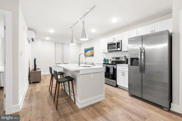 a kitchen with a sink stainless steel appliances and white cabinets