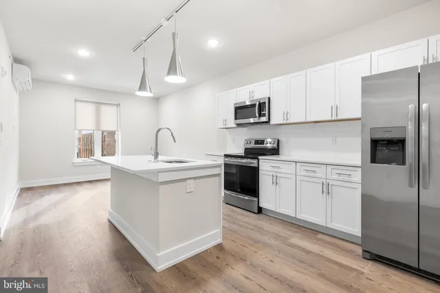 a kitchen with granite countertop a sink stainless steel appliances and cabinets