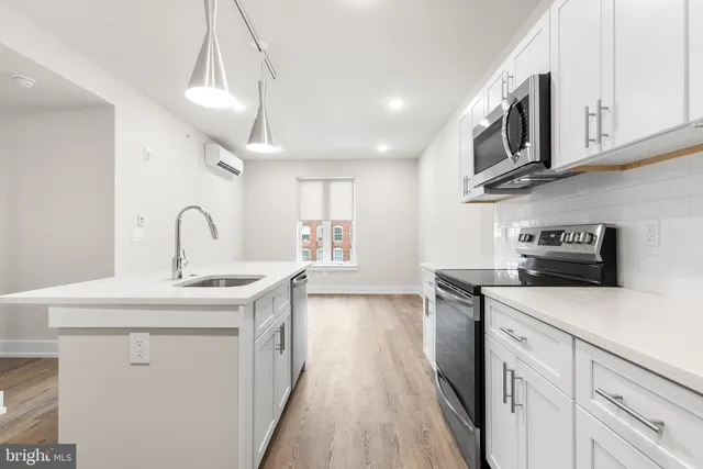 a kitchen with stainless steel appliances granite countertop a sink and dishwasher a stove top oven with wooden floor