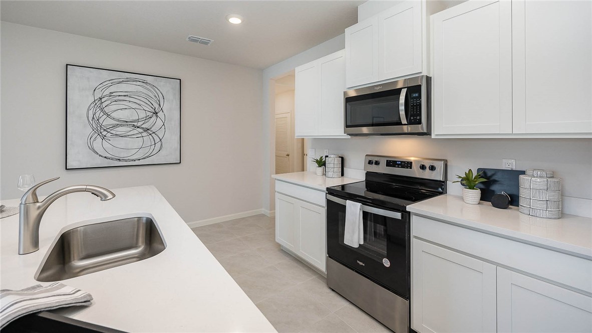 608 Lawson Street Sebastian, FL 32958 - Photo 13 of 30 a kitchen with stainless steel appliances granite countertop a sink a stove a microwave and cabinets