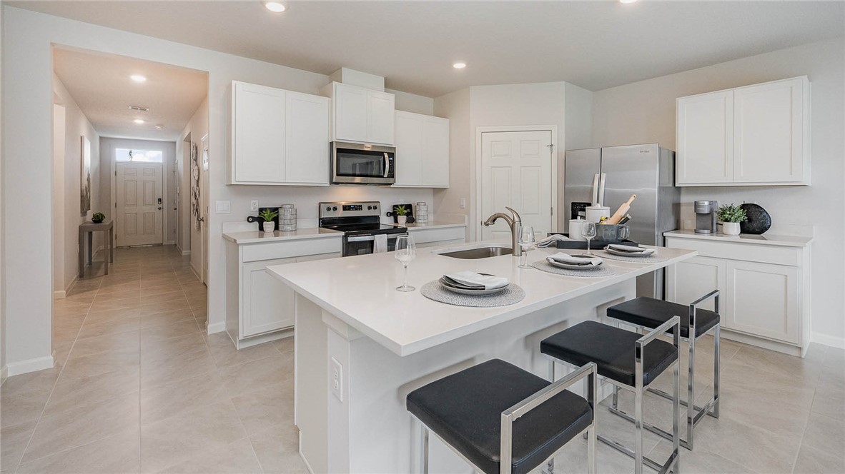 608 Lawson Street Sebastian, FL 32958 - Photo 8 of 30 a kitchen with stainless steel appliances a sink a stove a table and chairs