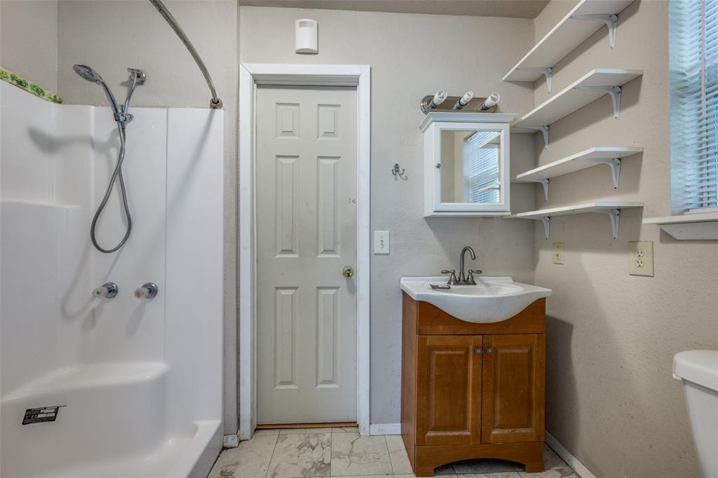 970 McReynolds Road Sanger, TX 76266 - Photo 15 of 25 a bathroom with a sink a toilet and shower
