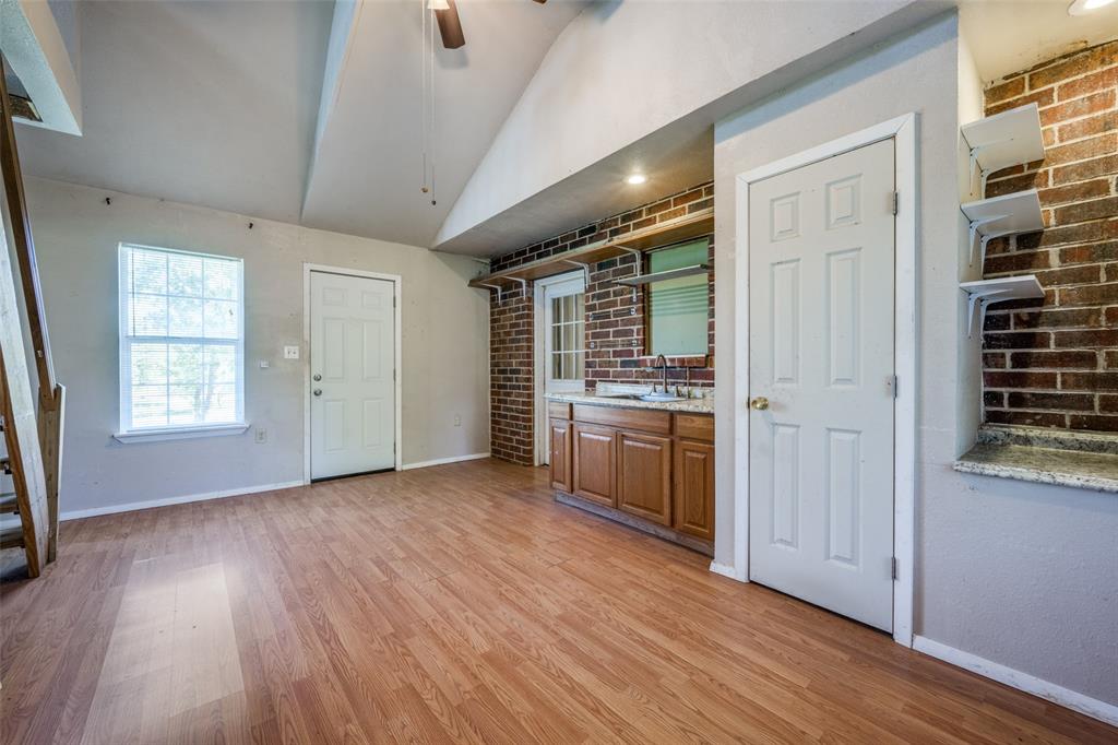 970 McReynolds Road Sanger, TX 76266 - Photo 18 of 25 wooden floor in an empty room with a kitchen