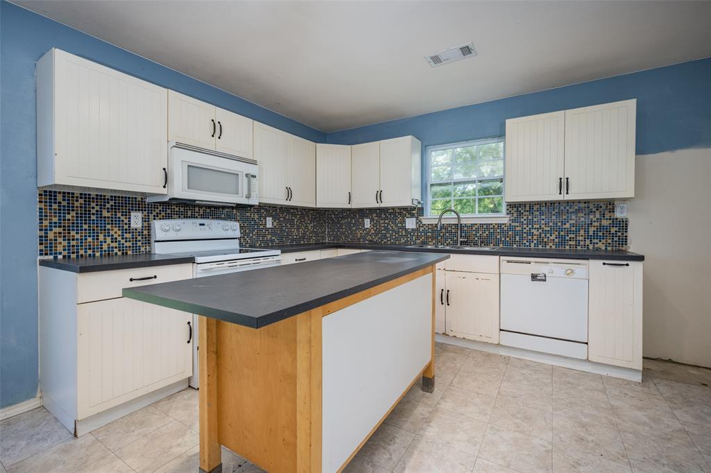 970 McReynolds Road Sanger, TX 76266 - Photo 5 of 25 a kitchen with stainless steel appliances granite countertop a sink stove and white cabinets