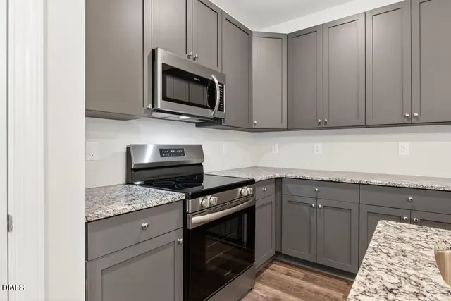 a kitchen with granite countertop cabinets stainless steel appliances and a sink