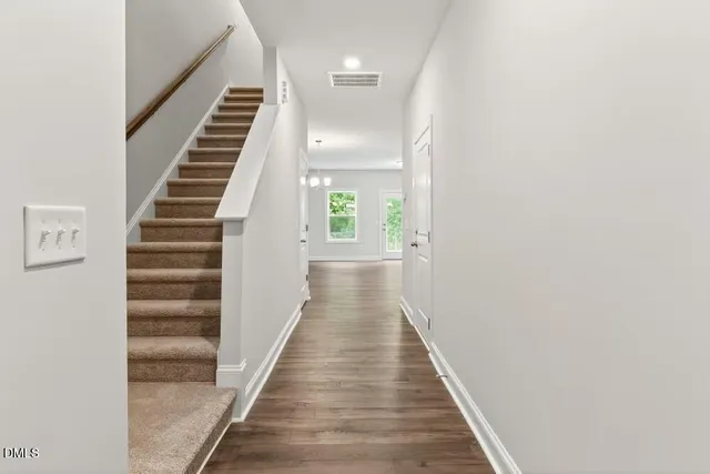 a view of a hallway with wooden floor and entryway