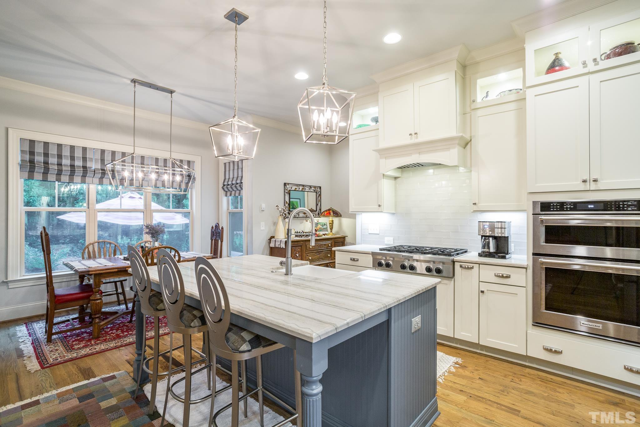 1921 Banbury Road Raleigh, NC 27608 - Photo 12 of 30 a kitchen with a stove a chandelier and wooden cabinets