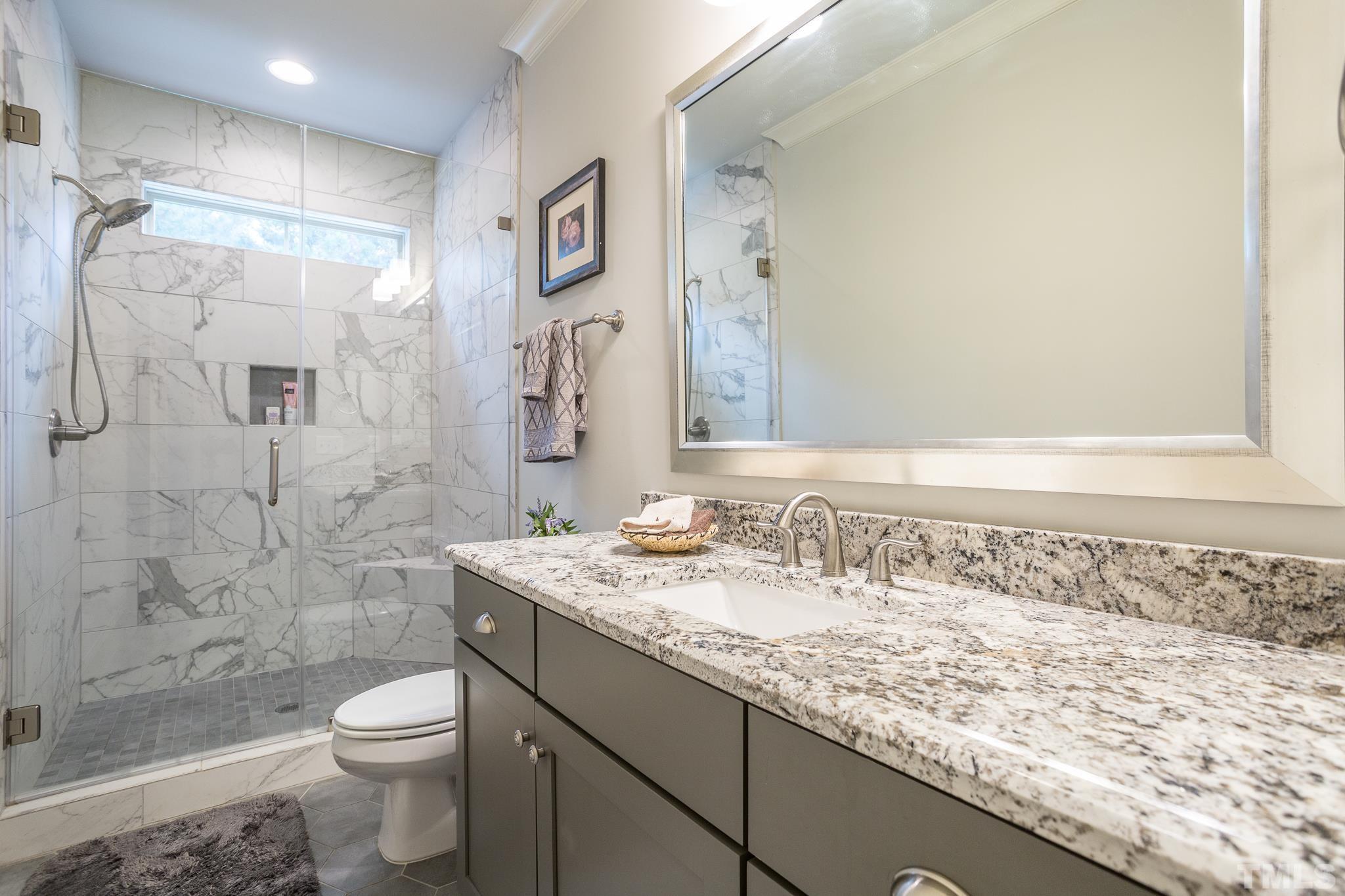 1921 Banbury Road Raleigh, NC 27608 - Photo 23 of 30 a bathroom with a granite countertop sink a toilet and shower