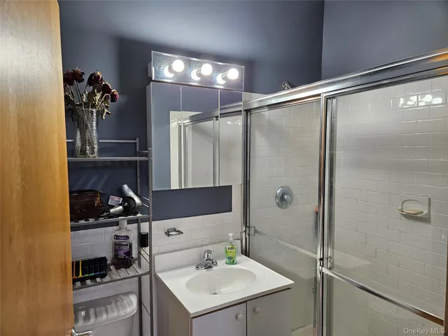 a bathroom with a sink mirror and shower