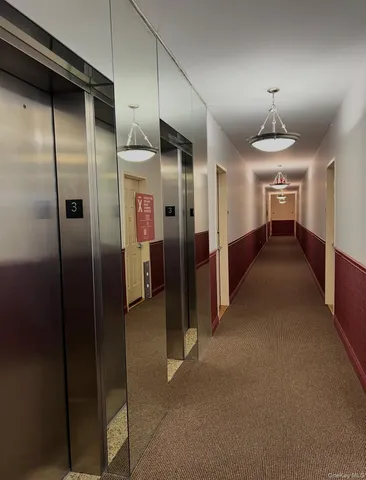 a view of a hallway with wooden shelves