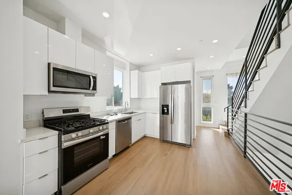 a large kitchen with stainless steel appliances granite countertop a stove and a sink