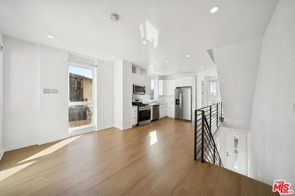 a kitchen with stainless steel appliances a refrigerator a stove top oven a sink and a refrigerator