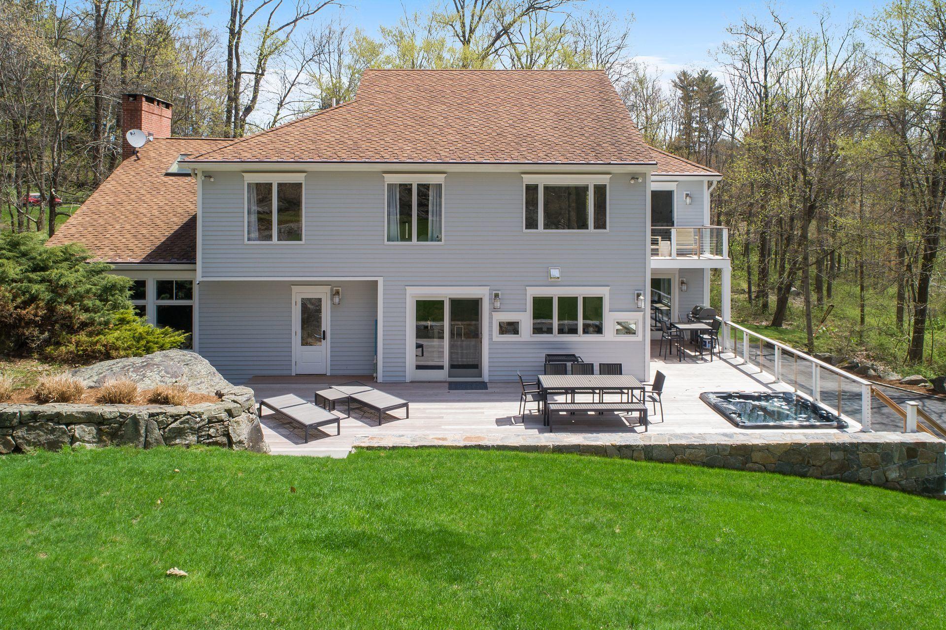 38 Farview Farm Road Redding, CT 06896 - Photo 26 of 34 a view of a brick house with a yard patio and a table and chairs