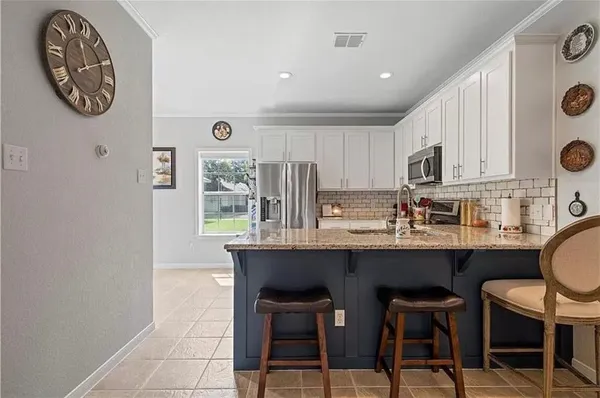 a kitchen with stainless steel appliances granite countertop a stove a sink and a refrigerator
