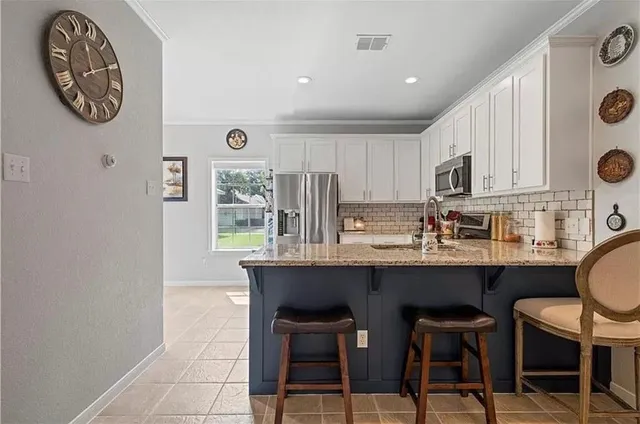 a kitchen with stainless steel appliances granite countertop a stove a sink and a refrigerator