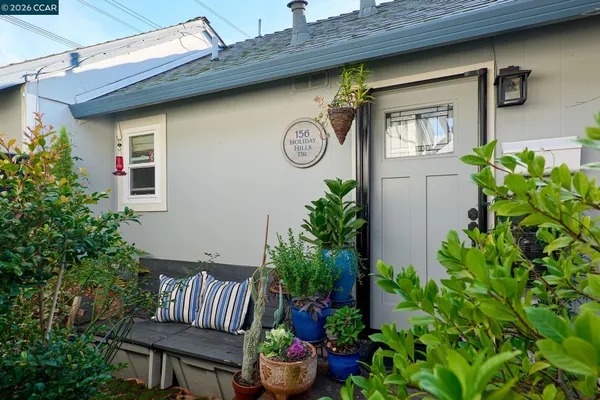 a front view of a house with outdoor seating and flowers in it