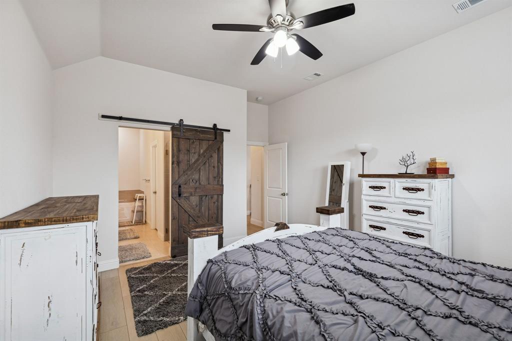 388 Montague Street Pilot Point, TX 76258 - Photo 19 of 28 a bedroom with a bed and a walk in closet