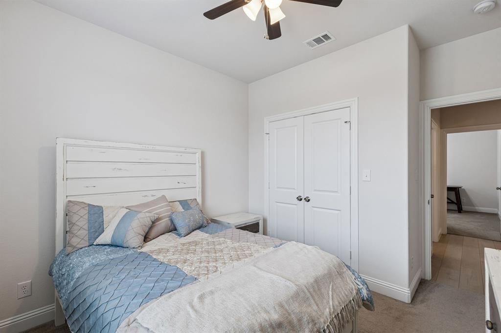 388 Montague Street Pilot Point, TX 76258 - Photo 22 of 28 a bedroom with a bed and a chandelier