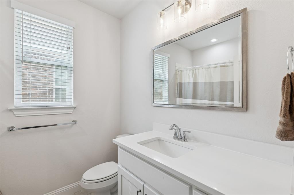 388 Montague Street Pilot Point, TX 76258 - Photo 23 of 28 a bathroom with a sink a toilet and a mirror