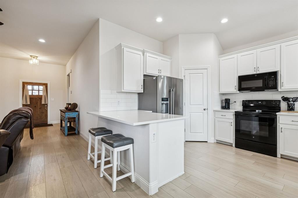388 Montague Street Pilot Point, TX 76258 - Photo 8 of 28 a kitchen with stainless steel appliances a stove a sink a refrigerator a stove a dining table and chairs