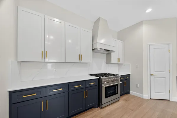 a kitchen with granite countertop a sink stove and cabinets