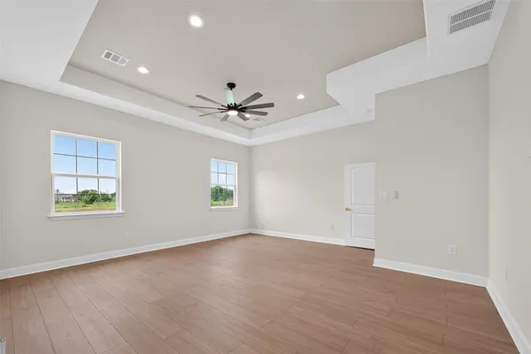 a view of a big room with wooden floor and windows in a room