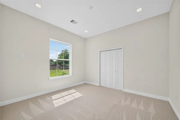 an empty room with windows and closet