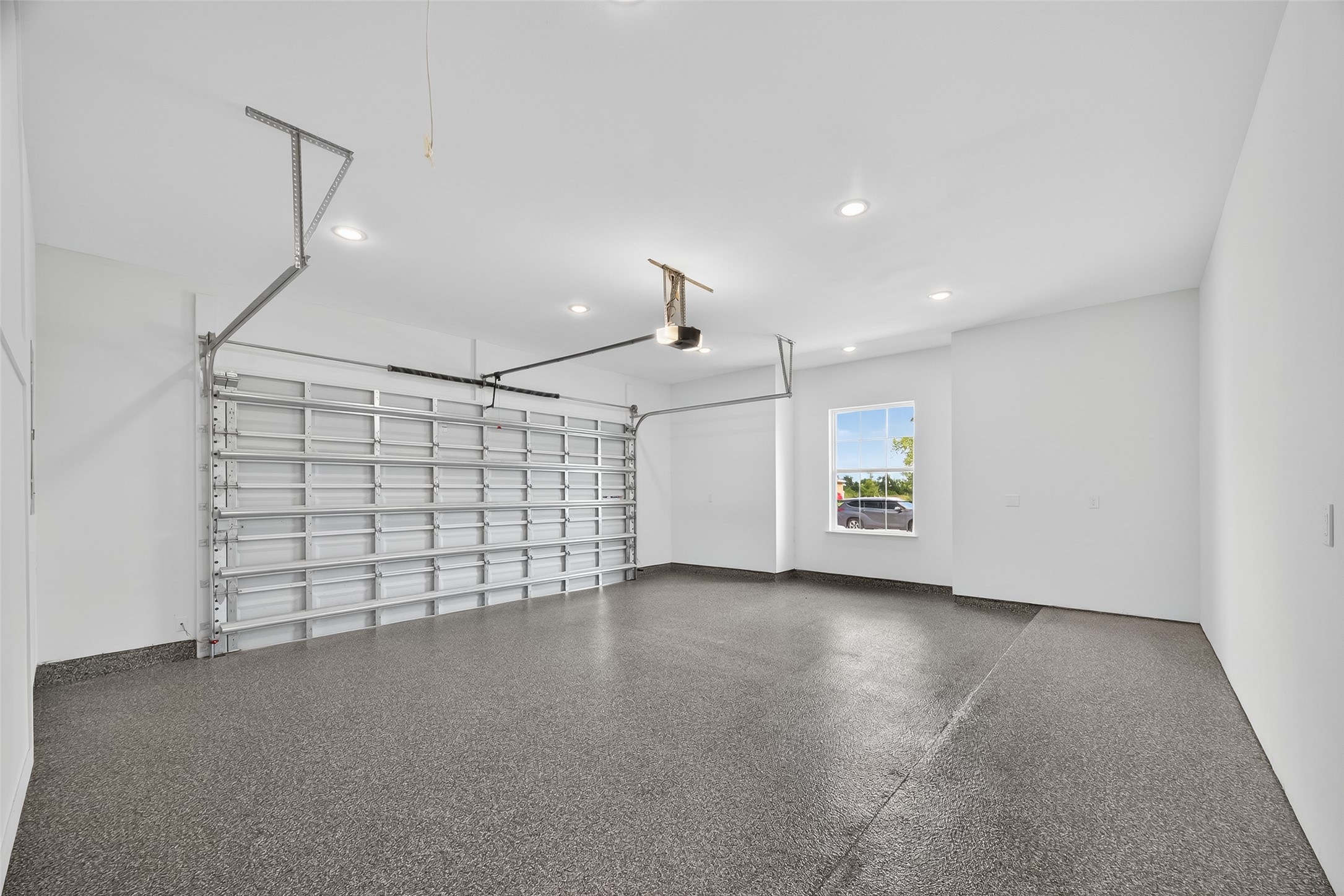 7717 Prairie Street Hitchcock, TX 77563 - Photo 39 of 43 This spacious two-car garage features energy-efficient spray foam-insulated walls and sleek epoxy flooring for enhanced functionality and style.