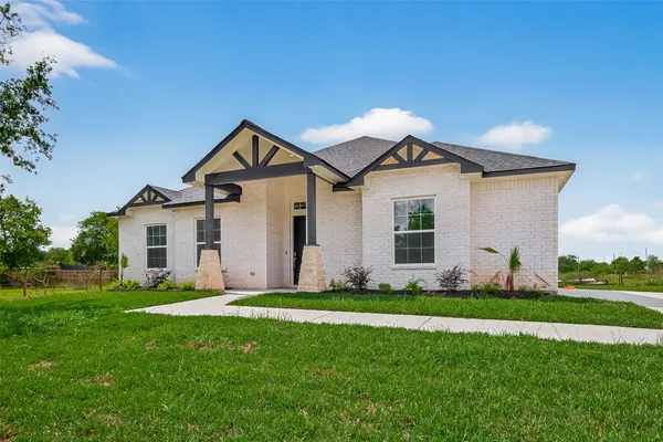 a front view of a house with a garden and yard