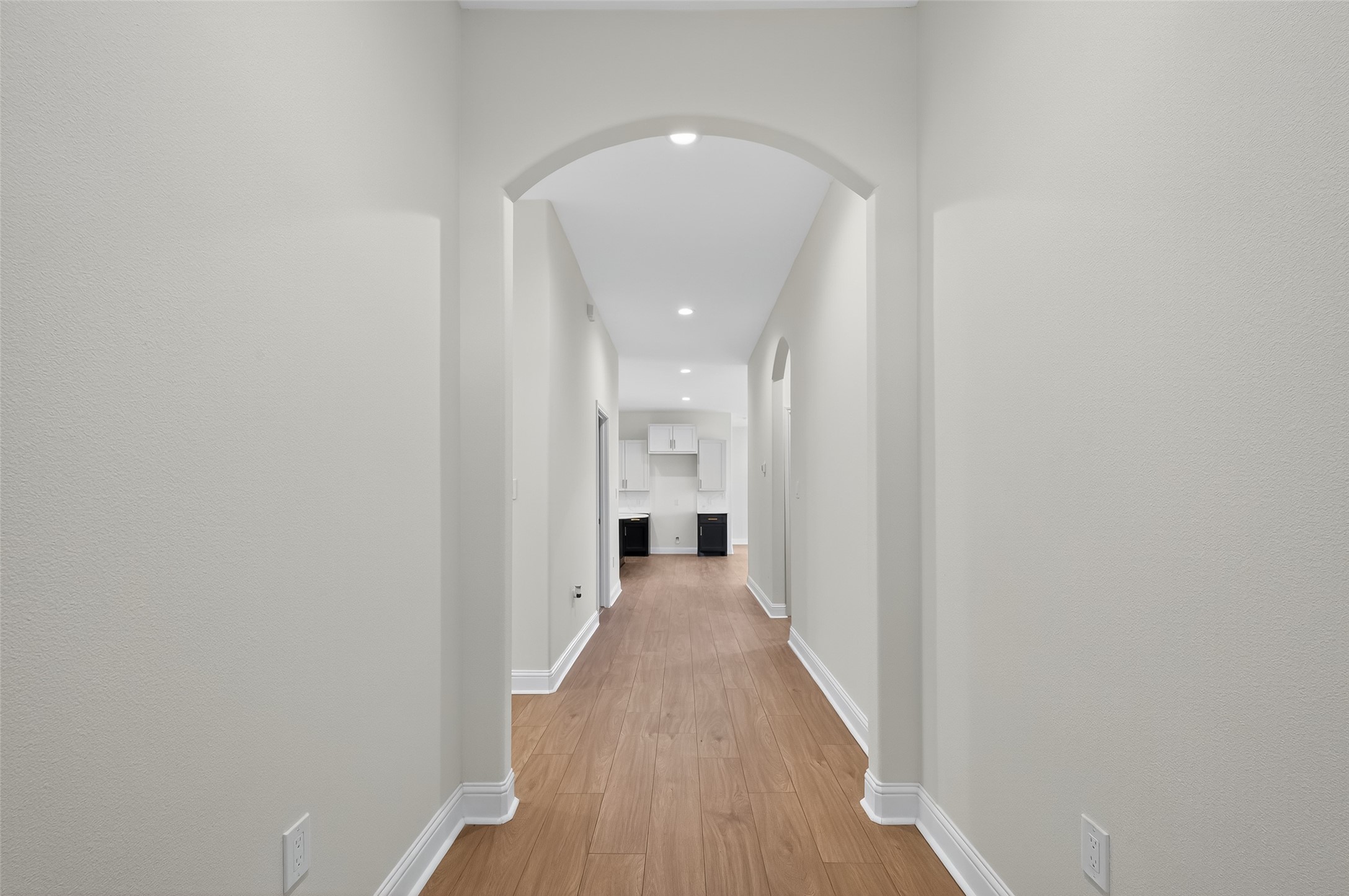 7717 Prairie Street Hitchcock, TX 77563 - Photo 10 of 43 Chic and inviting hallway with elegant archways and sleek hardwood floors, offering a warm welcome to your home.