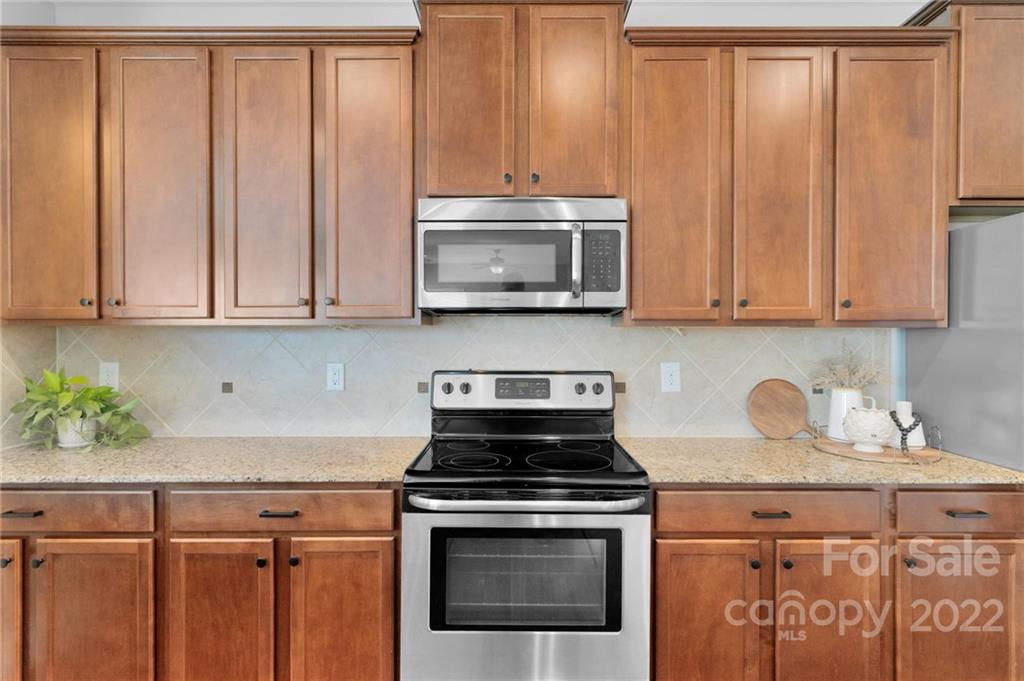 1640 Ridgehaven Road Waxhaw, NC 28173 - Photo 5 of 36 a kitchen with granite countertop a stove a microwave and cabinets