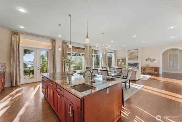 a large kitchen with kitchen island a large counter top space a sink stainless steel appliances and cabinets