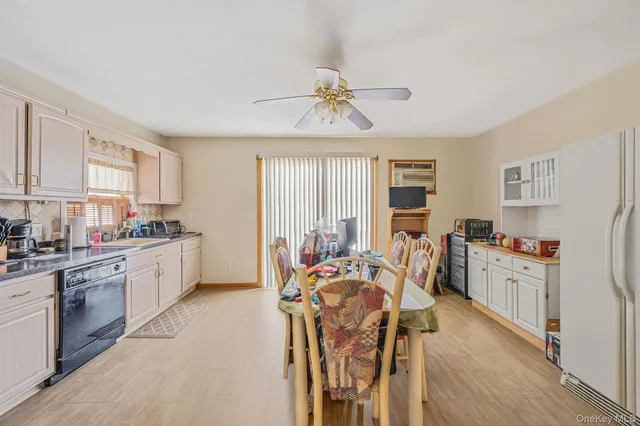 a kitchen with stainless steel appliances a table chairs refrigerator and cabinets