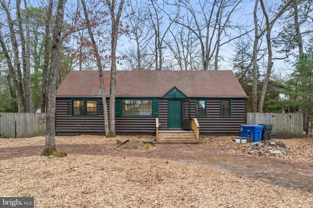 a view of house with backyard and trees