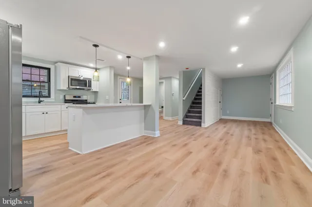 a view of a kitchen with wooden floor and electronic appliances