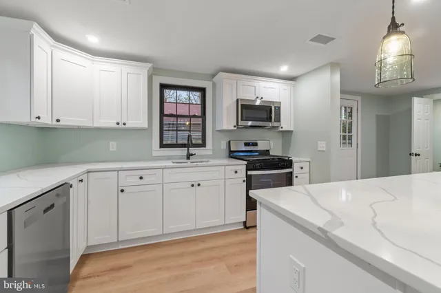 a kitchen with granite countertop a sink stainless steel appliances and cabinets
