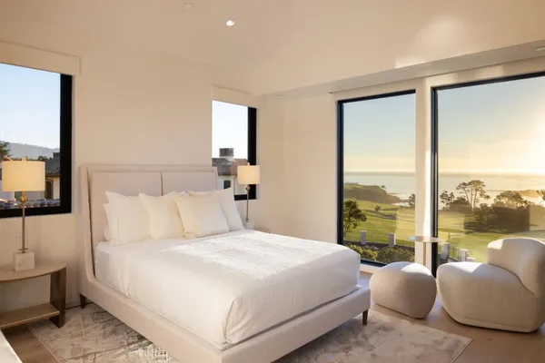 a bedroom with a bed lamp and large window