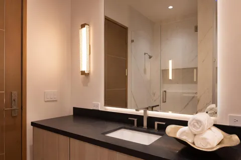 a bathroom with a granite countertop sink toilet and shower