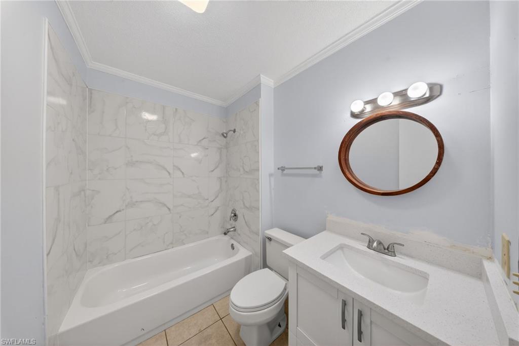 5300 Treetops Drive, Unit I206 Naples, FL 34113 - Photo 13 of 17 a bathroom with a sink a toilet and a mirror