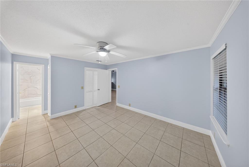 5300 Treetops Drive, Unit I206 Naples, FL 34113 - Photo 15 of 17 a view of an empty room with window and chandelier fan