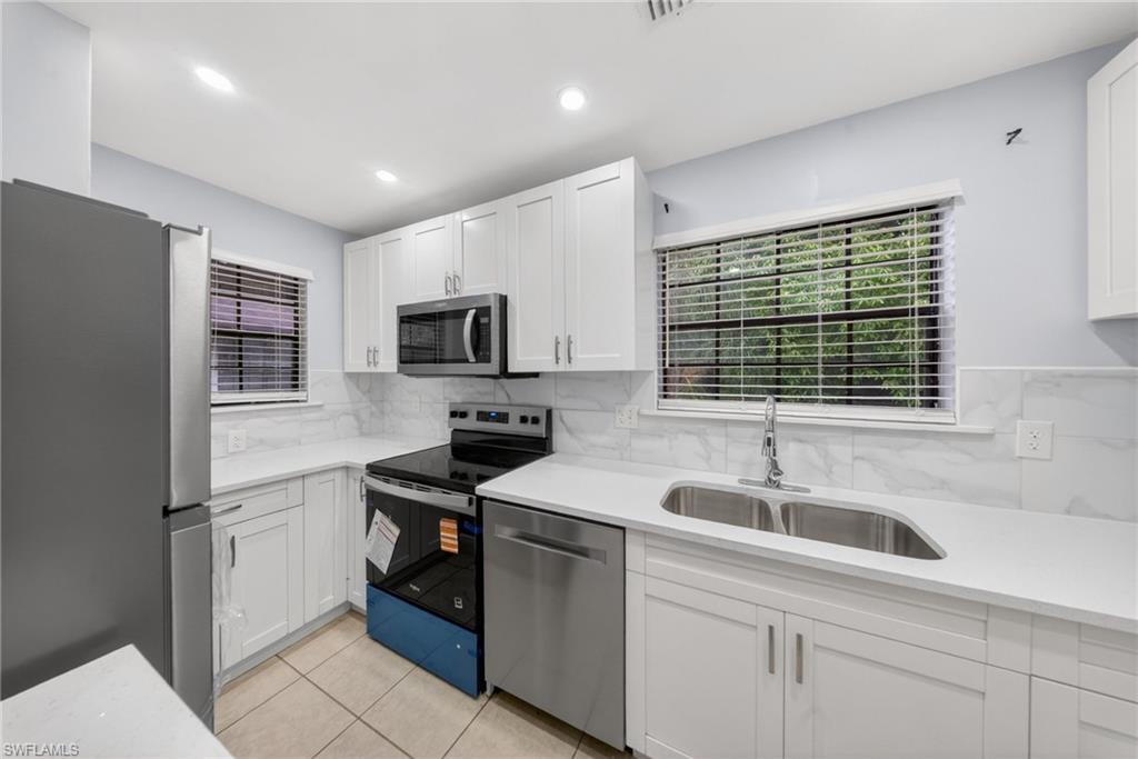 5300 Treetops Drive, Unit I206 Naples, FL 34113 - Photo 4 of 17 a kitchen with a sink appliances and cabinets