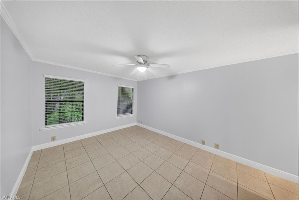 5300 Treetops Drive, Unit I206 Naples, FL 34113 - Photo 7 of 17 an empty room with windows and chandelier fan
