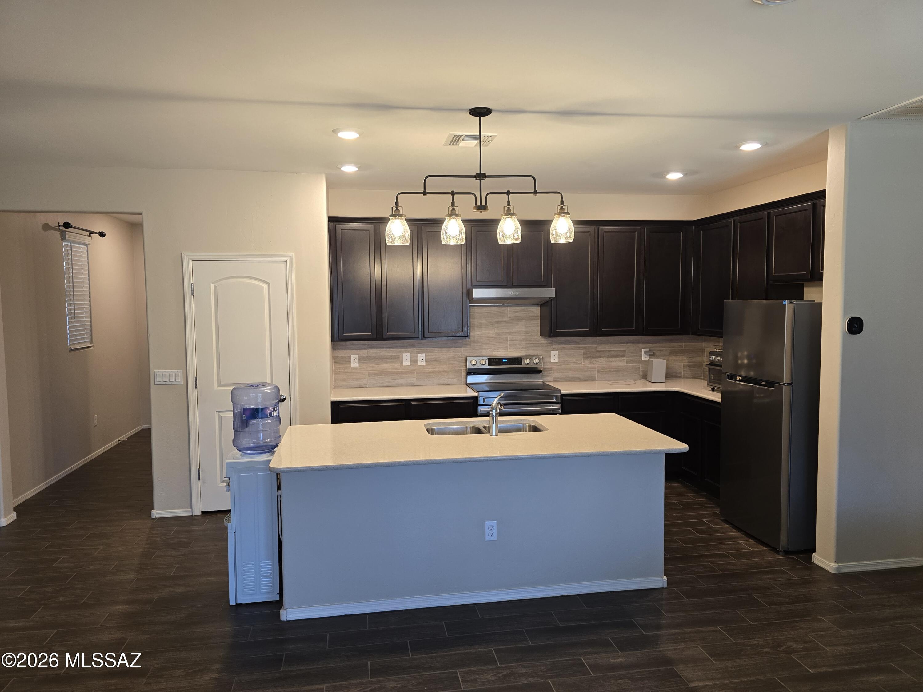 6151 South Antrim Loop Tucson, AZ 85706 - Photo 4 of 13 a kitchen with stainless steel appliances granite countertop a refrigerator a sink and a stove