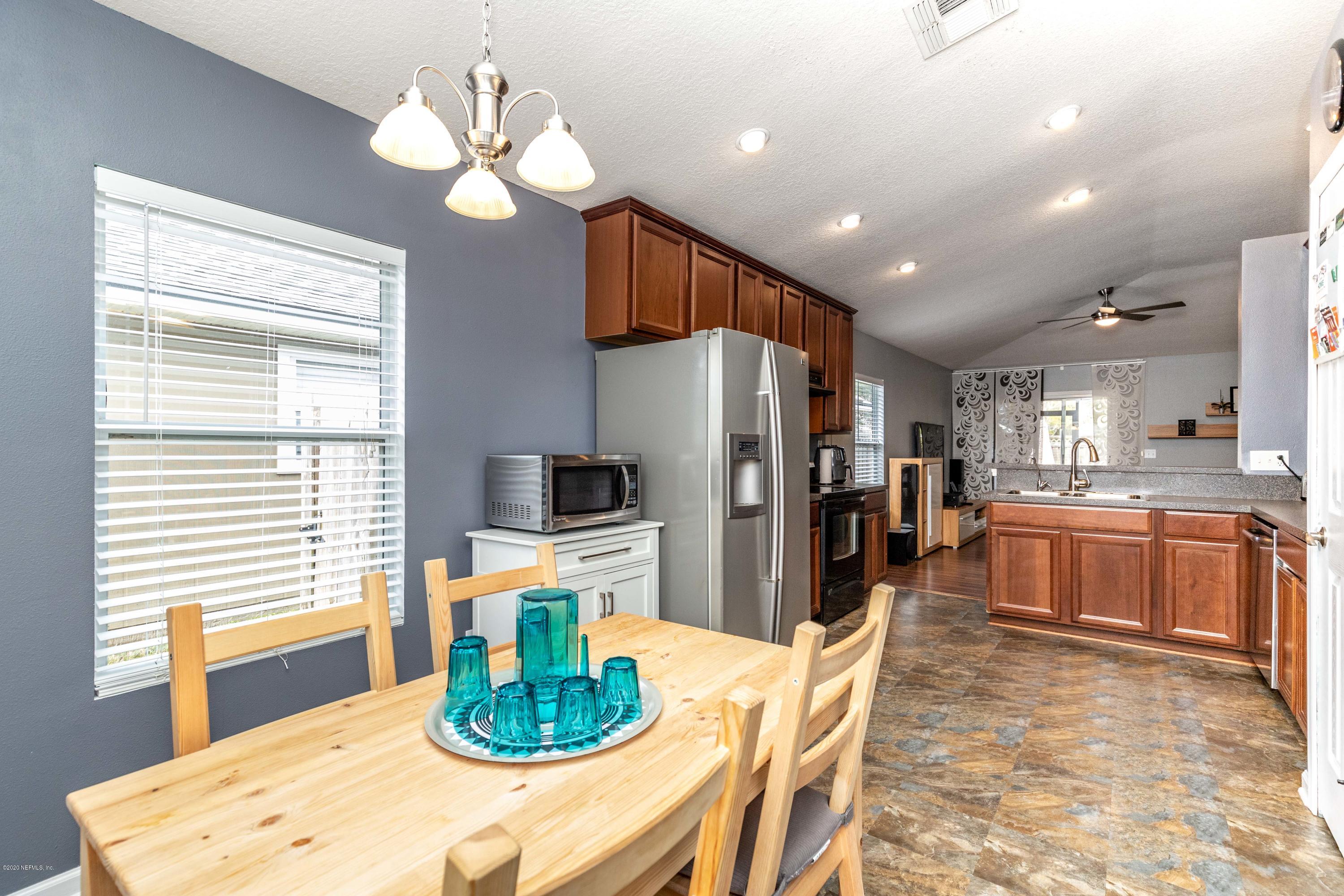816 Crystal Spring Way St. Augustine, FL 32092 - Photo 7 of 44 a kitchen with stainless steel appliances kitchen island granite countertop a refrigerator a stove a sink dishwasher with a dining table and chairs